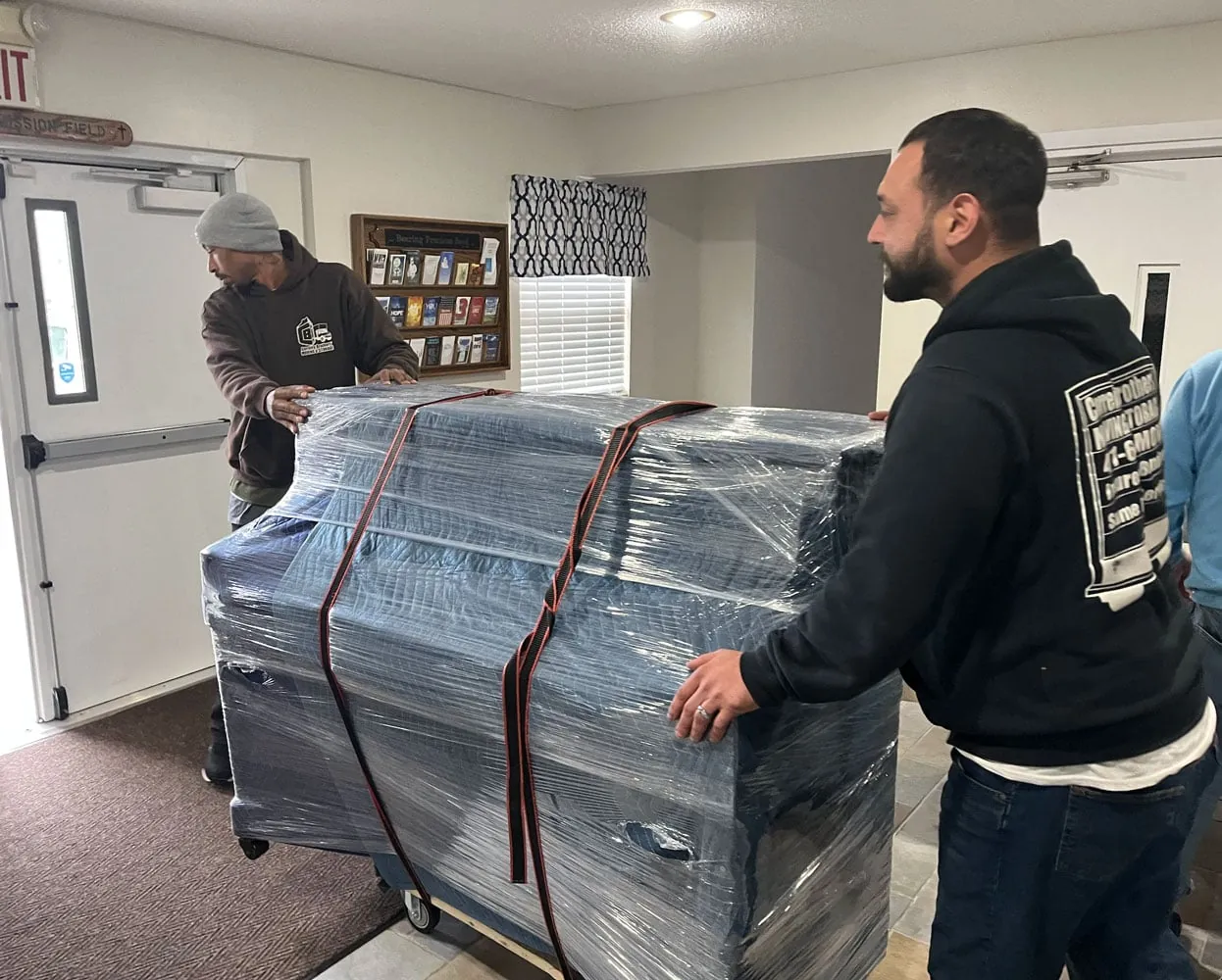 Mover standing beside a wrapped item indoors
