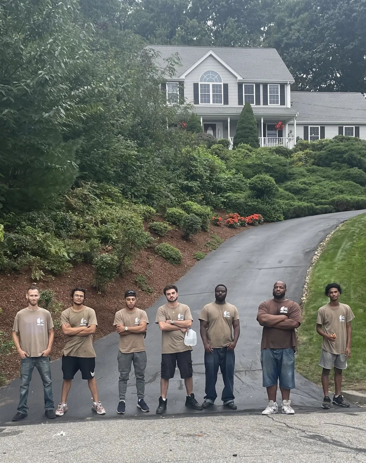 Correira Brothers team lined up in the driveway of a large home